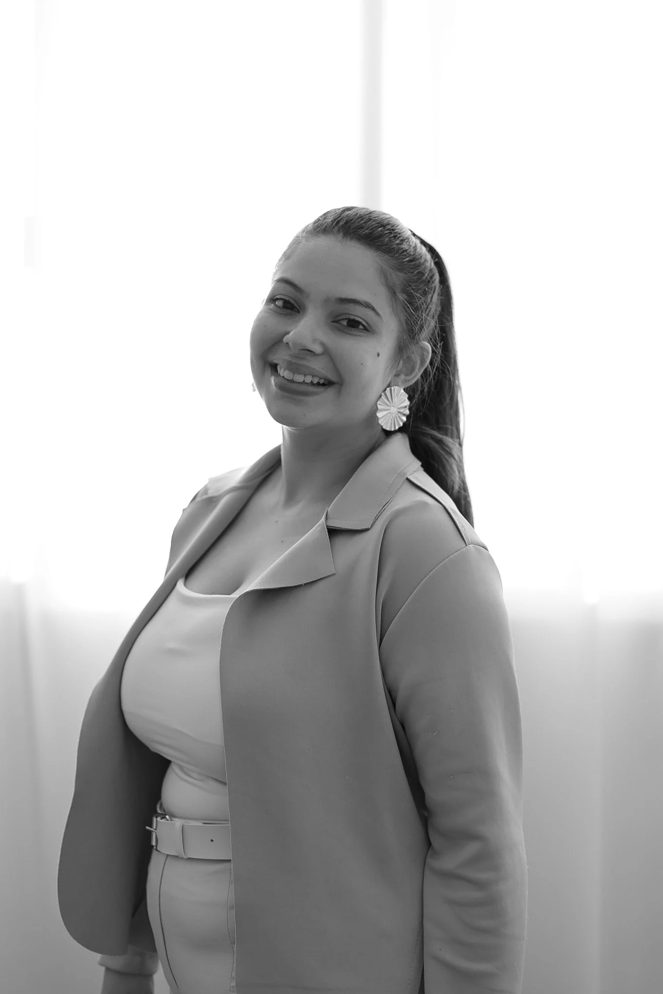 Bruna Luna sorri em um retrato profissional em preto e branco.