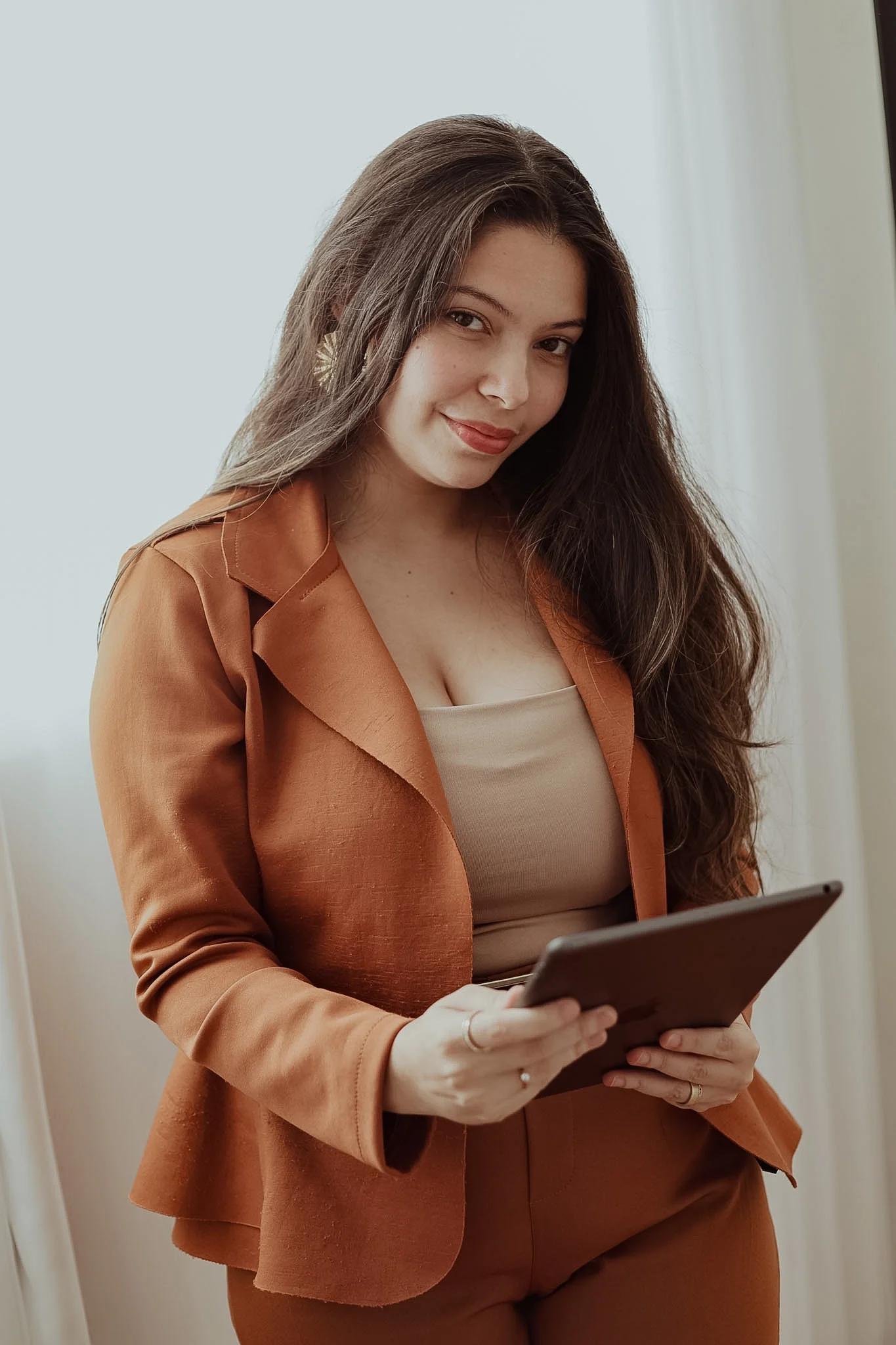 Bruna Luna, cerimonialista, em retrato profissional com um tablet.